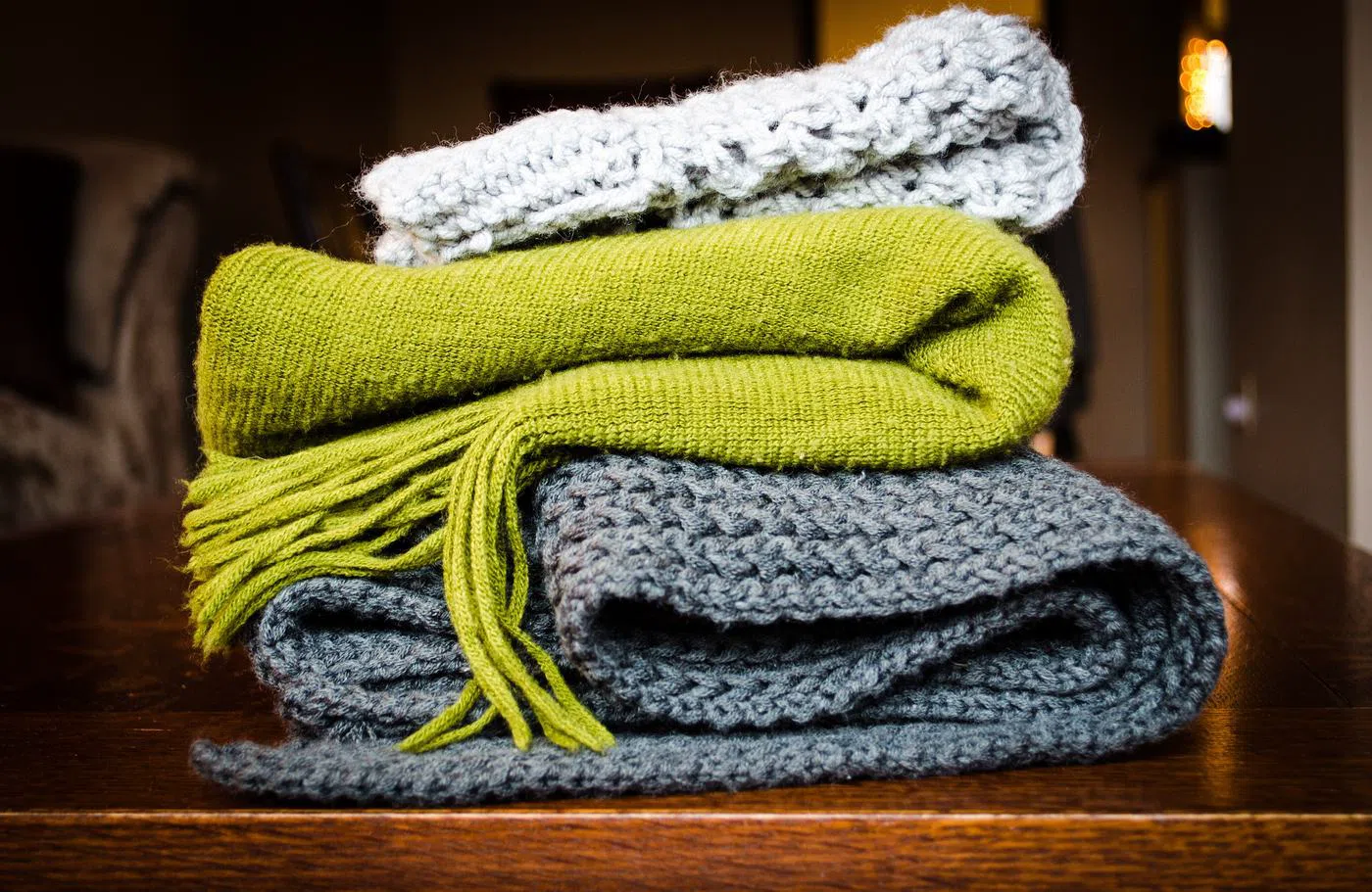 Wool blankets folded in a stack, moss on top of slate.