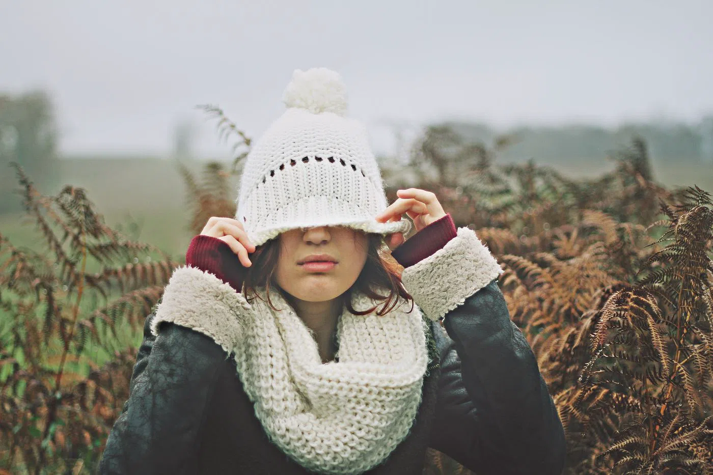 The wool scarf in cream, wound high against the cold.