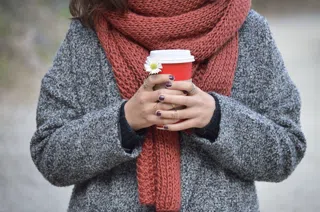 The wool scarf in rust, worn over a grey coat.