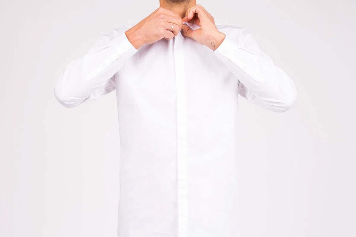 An ecru linen shirt, buttoned to the collar.