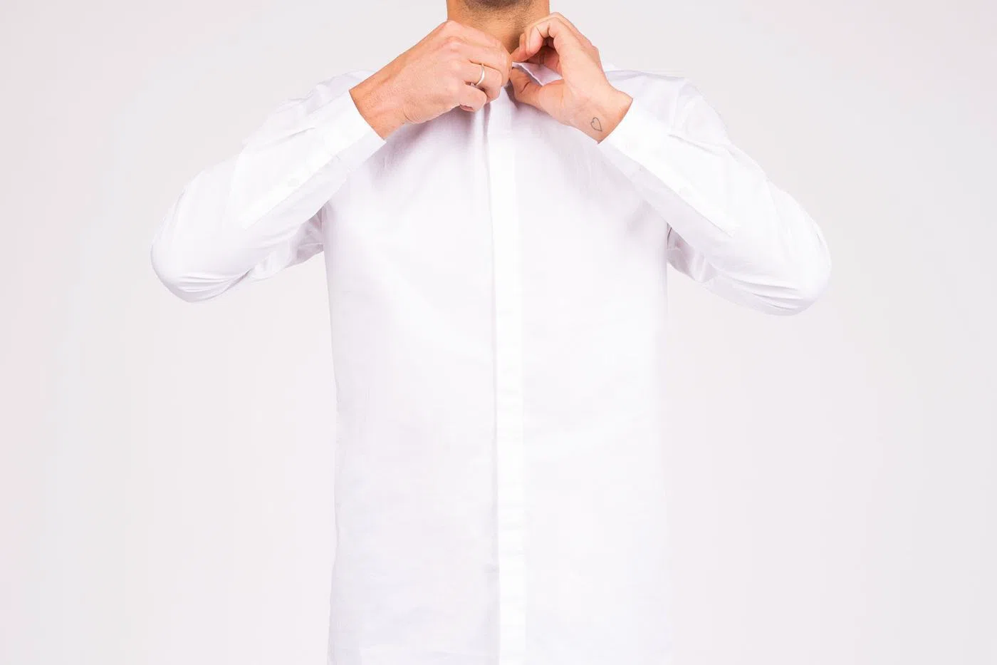 An ecru linen shirt, buttoned to the collar.