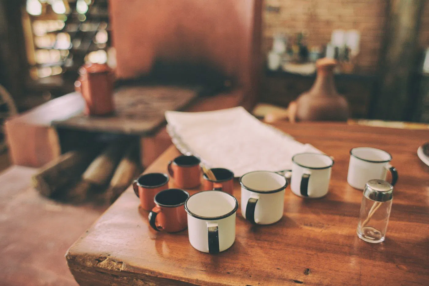 Enamel mugs lined up along a workbench.